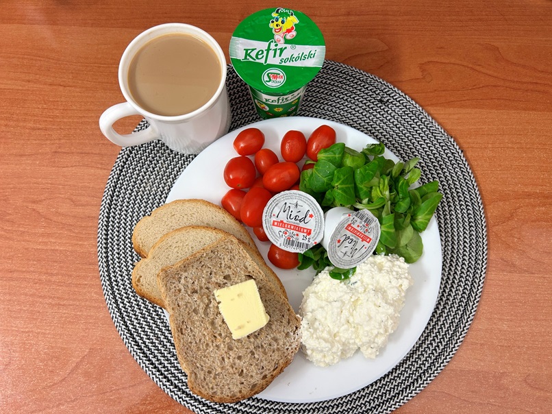 Na Zdjęciu : Kefir 2%, Kawa zbożowa z mlekiem, Chleb mieszany pszenno-żytni, Chleb Graham, Masło extra 82%, Miód, Twarożek, Pomidorki koktajlowe, Roszponka